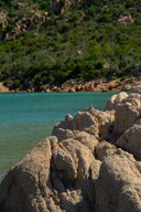 Vue d'une plage Corse avec roche, eau claire et forêt