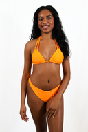 Femme portant le haut de maillot de bain Sasha orange et le bas de maillot de bain Hena orange sur fond blanc